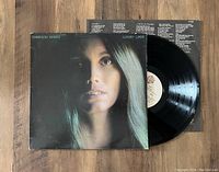 Front view of the Luxury Liner vinyl album jacket and vinyl record laid partially out of sleeve, showing cover art and record label.