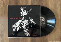 Front cover of Joan Baez vinyl record LP showing black and white photo of Joan Baez with guitar and visible Vanguard label on the vinyl record.