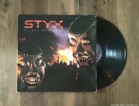 Vinyl record LP jacket and vinyl disc of Styx's Kilroy Was Here album shown partially pulled out of sleeve. Jacket shows minor wear, vinyl surface visually clean and shiny.