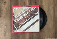 Photo showing the front cover of The Beatles 1962-1966 2LP vinyl record album with records partially visible.