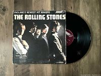 Front cover photo showing album artwork with band photo and the vinyl record partially out of the sleeve, highlighting album condition and the record label.