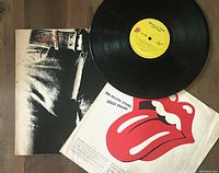 Photo shows The Rolling Stones Sticky Fingers vinyl record LP including jacket, vinyl, and insert.