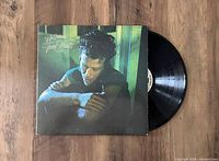 Photo showing original album jacket with Tom Waits on cover alongside the vinyl record partially removed from the jacket.