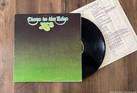 Vinyl record partially pulled out from original album jacket with lyric insert sheet visible underneath.