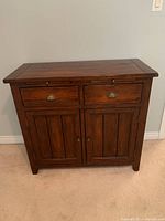 Front view of the rustic wooden hutch cabinet showing two drawers and two doors.
