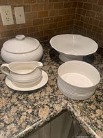 Wide view of all four cream-coloured Sophie Conran serving dishes on a countertop showing their size and layout.