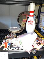 Assorted pins, patches, key chains, and an AMF bowling pin on a grill shelf