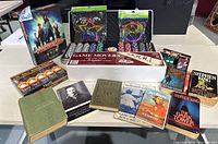 Full lot overview showing board games, poker chips, novels, Magic Svengali deck, golf balls, and puzzles on a table.