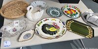 Wide view of all vintage platters and dishes including swan planter, turkey platter, fruit plate, and wicker basket.