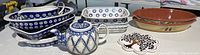 Overview of all pottery items including blue and white baking dishes, terracotta olive-decorated dish, teapot, and hot plate.
