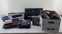 Overview of the full lot including consoles, keyboards, and box with miscellaneous items