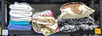 Image showing folded towels and pillows on shelf including white, blue and turquoise towels, decorative pillow covers and pillows.