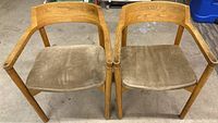 Pair of wooden arm chairs with light brown wood frames and brown felt cushioned seats, viewed from front and top showing armrests.