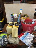 General layout of towels, wash mitts, and cleaning products on table with bucket.