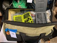 Fabric work bag open to reveal assorted bit cases and loose bits