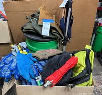 Various gloves, work gear and plumbing tools in a box.