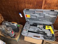 Two molded plastic carrying cases open: left holds Senco feed coils and case; right holds DeWalt yellow screw gun with metal feed attachments