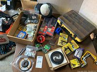 Overview of lot showing various boxes, carrying case and tools spread on table