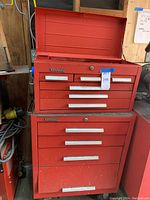 Two stacked red Kennedy toolboxes (top chest open) on casters, showing overall configuration and exterior condition
