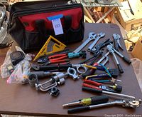 Full overview showing Husky tool bag and various tools including wrenches, pliers, tape measure, speed square, pipe cutter tools, and screwdrivers.