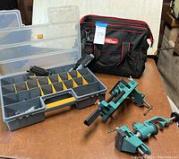 Overview of the lot including gray organizer with compartments, Pittsburgh vise with table clamp, and Hyper Tough tool bag on table surface.