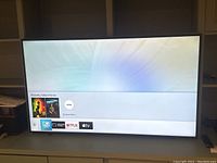 Front view powered on showing smart TV home screen with Netflix and Apple TV icons