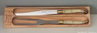 Carving knife and fork with bone handles in wooden box, labeled Laguiole