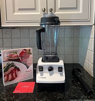 Blender assembled with pitcher, lid, tamper, recipe guide, and manual displayed