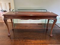 Full front view of the walnut sofa table showing carved apron and ball & claw feet