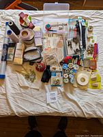 Full overview of all items including thread, needles, zippers, quilt binding, pincushions, and sewing patterns