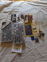 Overview photo showing the entire lot including bobbin cases, presser feet, needle packs, screwdriver, and loose bobbins.