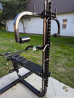 Full view of Soloflex home exercise machine showing frame, bench, and weight band pegs outdoors.