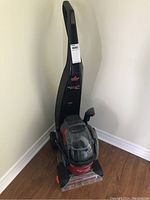 Full view of the Bissell ProHeat2X carpet cleaner showing upright form, hose, and base with cleaning head