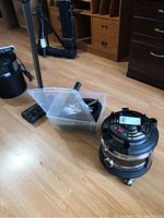 Wide view of canister vacuum with accessories on floor