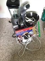 Photo shows Cuisinart blender, Salton mixer with attachments in bowl, Betty Crocker electric slicing knife box, and Philips sharpener on carpeted floor.