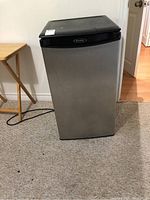 Front view of Danby mini refrigerator with stainless steel finish and black top, showing overall appearance and condition.