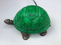 Top side view of the vintage green glass turtle lamp showing the detailed glass shell and metal feet.