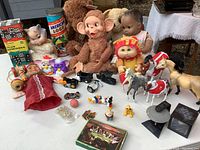 Wide shot of the lot showing all dolls, toys, and games including early American Girl Doll, stuffed monkey, small toy horses, puppet, and boxed games.