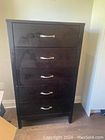 Full view front of chest of drawers with five drawers, dark wood veneer, and metal handles.