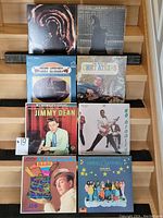Eight vinyl records in their original jackets showing artists Chet Atkins, Jimmy Dean, Bo Diddley, Amabec, and Mireille Matheu.