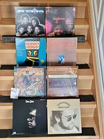 Front view of the eight vinyl records arranged on a step shelf. Records include Earth, Wind & Fire, Jackson 3, Cowboy Songs, Fantastic Johnny C, Great Country Hits compilations, and two Elton John records.