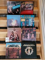 Eight vinyl records on stairs including The New Seekers, Elvis In Hollywood, Bachman-Turner Overdrive, and others