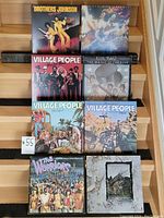 Front view of eight vinyl album jackets stacked showing artists and titles including Brothers Johnson, Blue Magic, and three Village People albums.