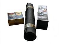 Rolled black outdoor barbeque mat with boxed beer can chicken roaster and BBQ steam brush beside it.