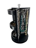 Photo of black revolving jewelry stand showing multiple compartments filled with various fashion jewelry pieces including rings and bracelets.