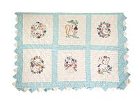 Front view of a rectangular baby quilt featuring six embroidered animal panels framed by light blue borders with scalloped edges.