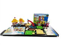 Overview of two partial Mega Blocks Smurfs play sets including playground pieces, beach pieces, instructions, and a box for the Playground set.