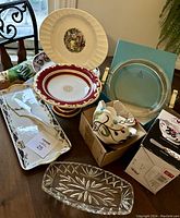 Photo of seven diverse serving dishes including Limoges plate, antique cake stand, glass dish, silver tray, and other items.