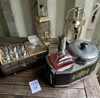 Overview of four musical decanter bottles and decorative barware setups showing brass bottles and music box bases