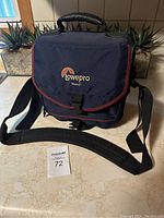 Lowepro Tour 2 camera bag shown with shoulder strap and handle, depicting condition and size.